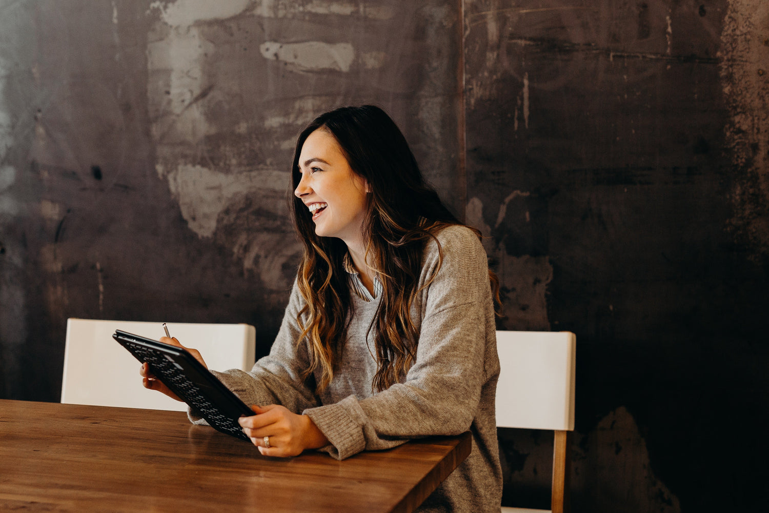 A happy lady holding a tablet in an office board room