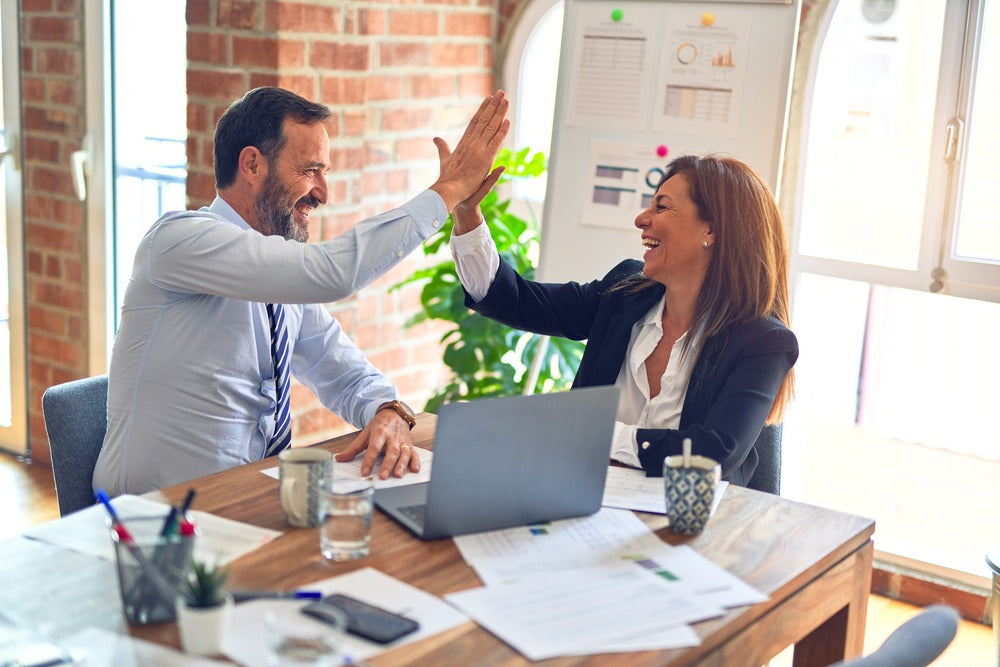An image of two professionals greeting each other in an office setting