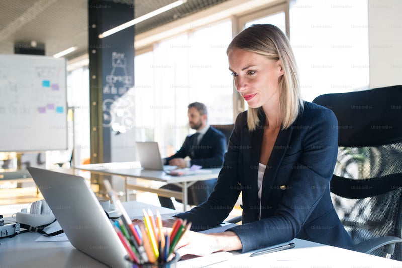 a lady working on her laptop in an open office workplace