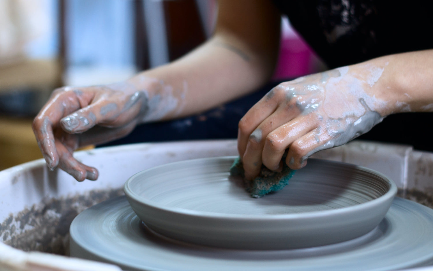 hands at a potters wheel shaping a plate. learn why creatives should use digital business cards vs traditional paper cards.
