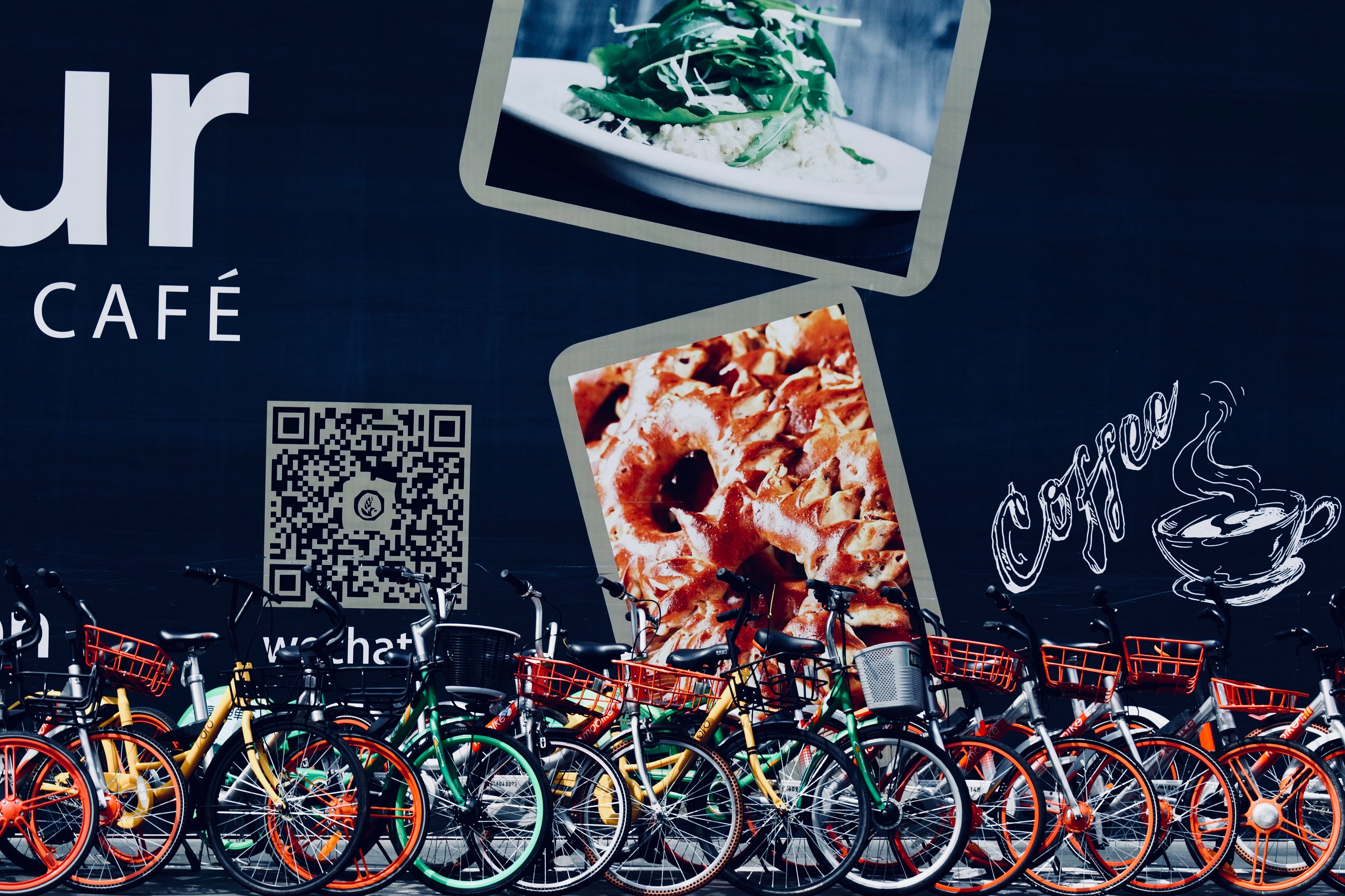 An image of a QR code printed on a wall behind packed bicycles.